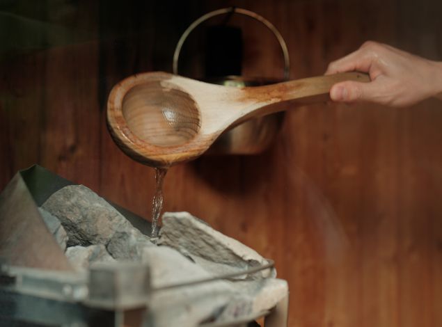 Water being poured over hot sauna stones at PEAK Health & Wellness Coeur d’Alene for heat therapy and muscle recovery