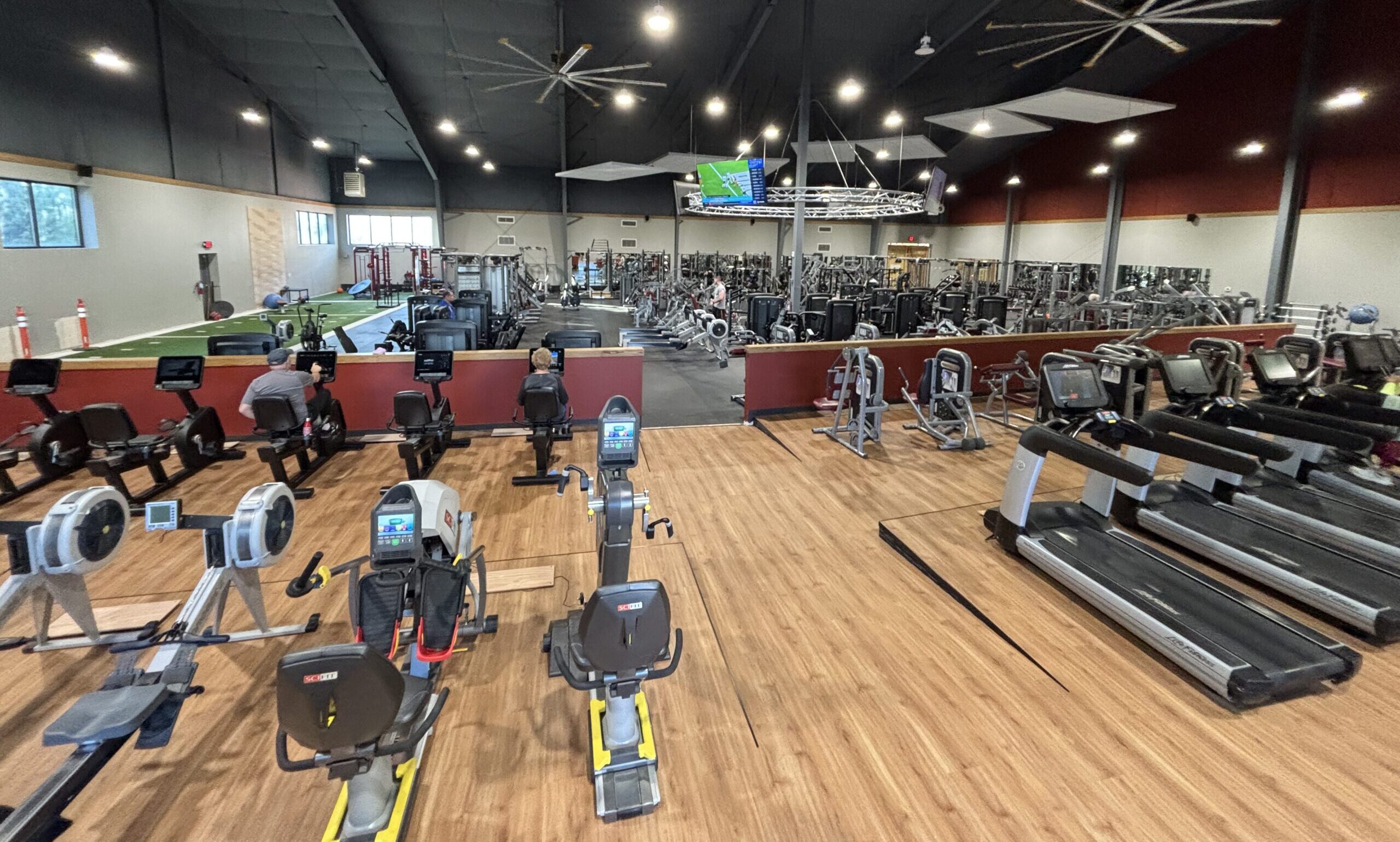Hero image of Peak Health & Wellness Center gym weight training floor in Idaho with free weights, benches, and squat racks.