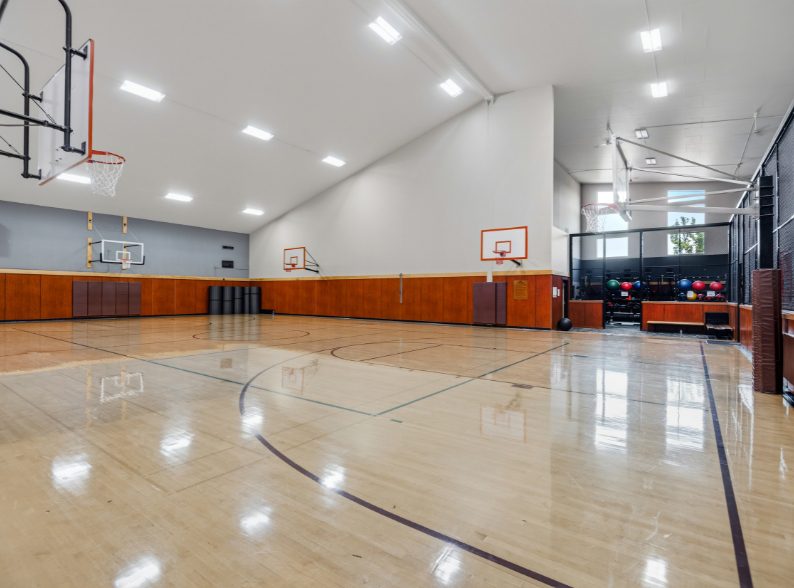 Full indoor basketball court with multiple hoops at Peak Health & Wellness Coeur d’Alene.