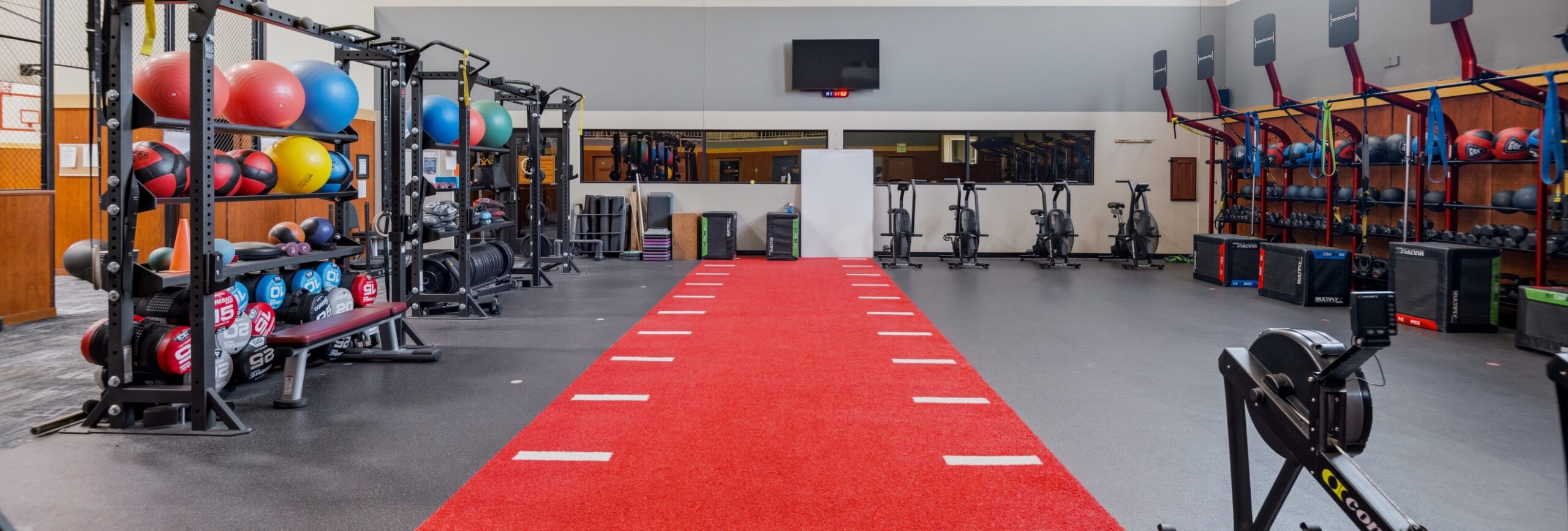 Functional training area with turf lane, rowing machine, air bikes, medicine balls, and plyometric equipment at Peak Health & Wellness Coeur d’Alene.