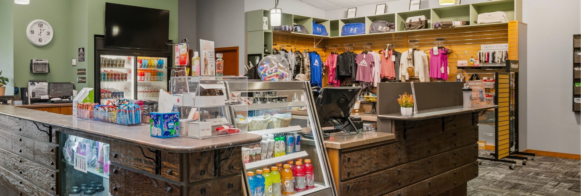 Juice bar at Peak Health & Wellness Coeur d'Alene with bottled drinks, snacks, fitness apparel, and retail merchandise.