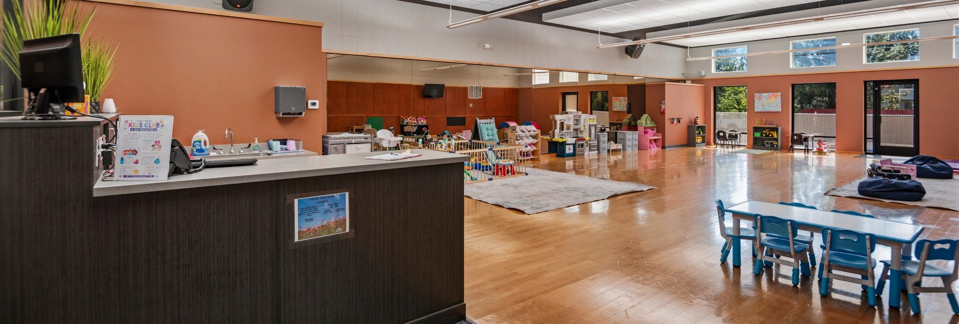 Kids Club childcare space at Peak Health & Wellness Coeur d'Alene with supervised play areas, toys, child-size tables, and seating.