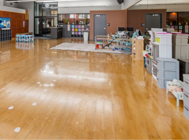 Open Kids Club childcare space at Peak Health & Wellness Coeur d'Alene with play zones, toys, child-size tables, and infant area.