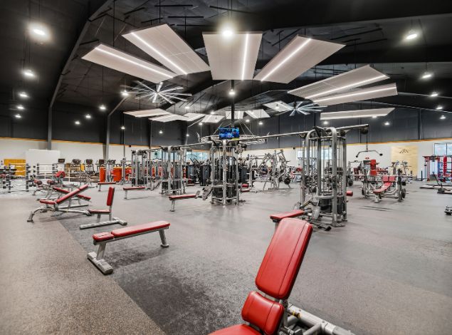Strength training floor at Peak Health & Wellness Coeur d'Alene with cable machines, benches, and weight-training equipment.