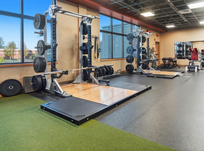 Squat racks, barbells, weight plates, lifting platforms, and turf training space at Peak Health & Wellness Hayden.