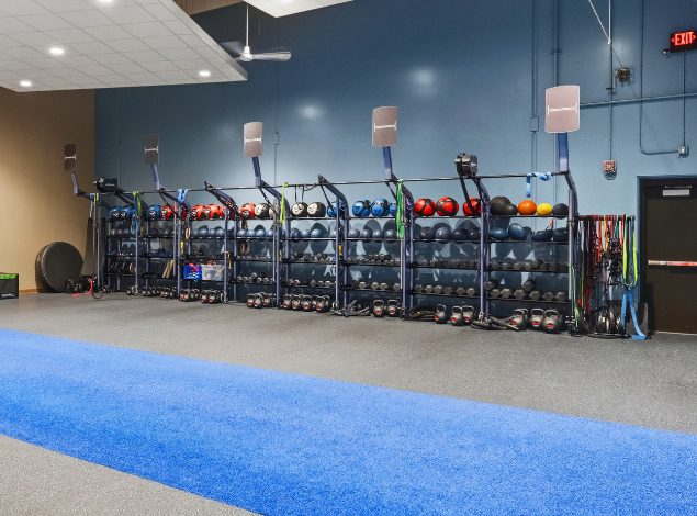 Functional training equipment at Peak Health & Wellness Hayden, including medicine balls, kettlebells, dumbbells, resistance bands, and a turf training lane.