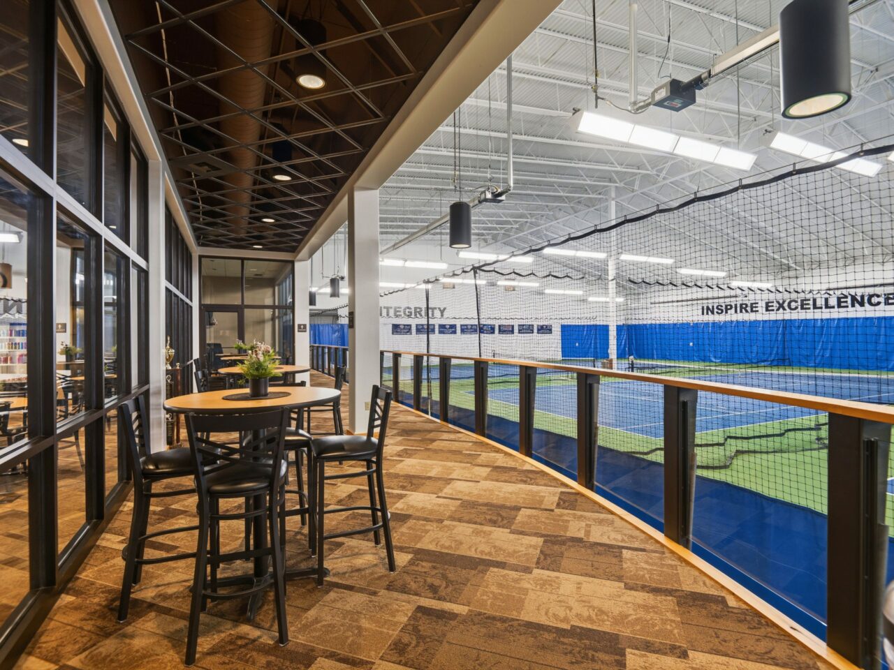 Member seating area overlooking the indoor tennis courts at Peak Health & Wellness Hayden.