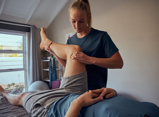 physical therapist working with client in a modern gym