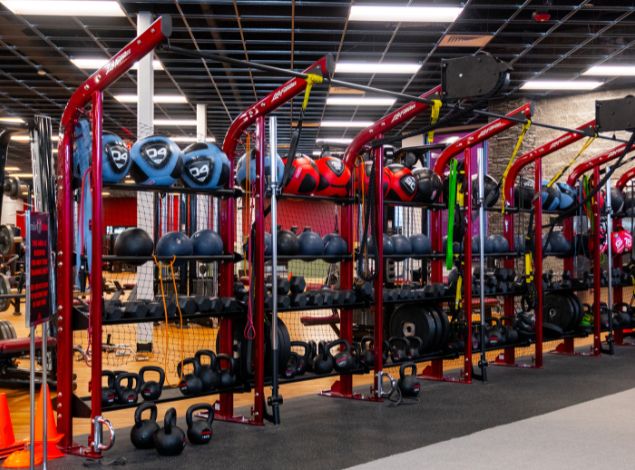 Functional training rigs at Peak Health & Wellness Post Falls with medicine balls, kettlebells, dumbbells, suspension trainers, and resistance bands.