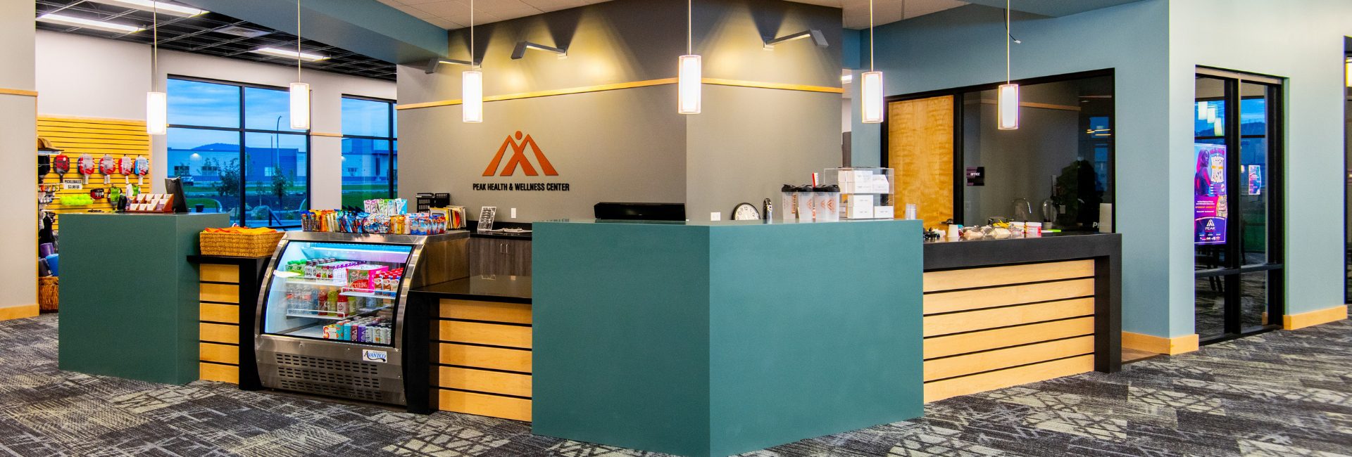 Juice bar and front desk at Peak Health & Wellness Post Falls with bottled drinks, snacks, and grab-and-go refreshments.