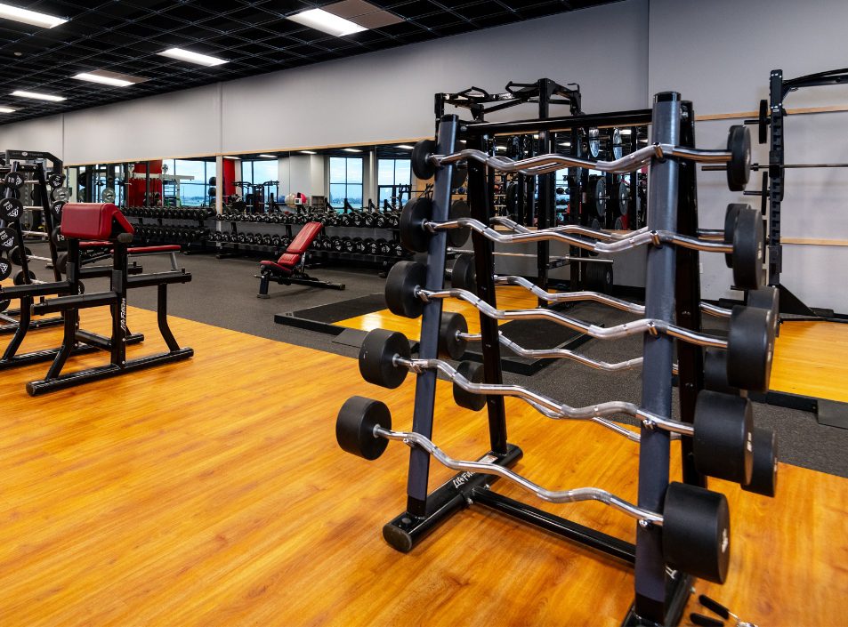 EZ barbells, dumbbells, benches, and power racks in the strength and free weights area at Peak Health & Wellness Post Falls.