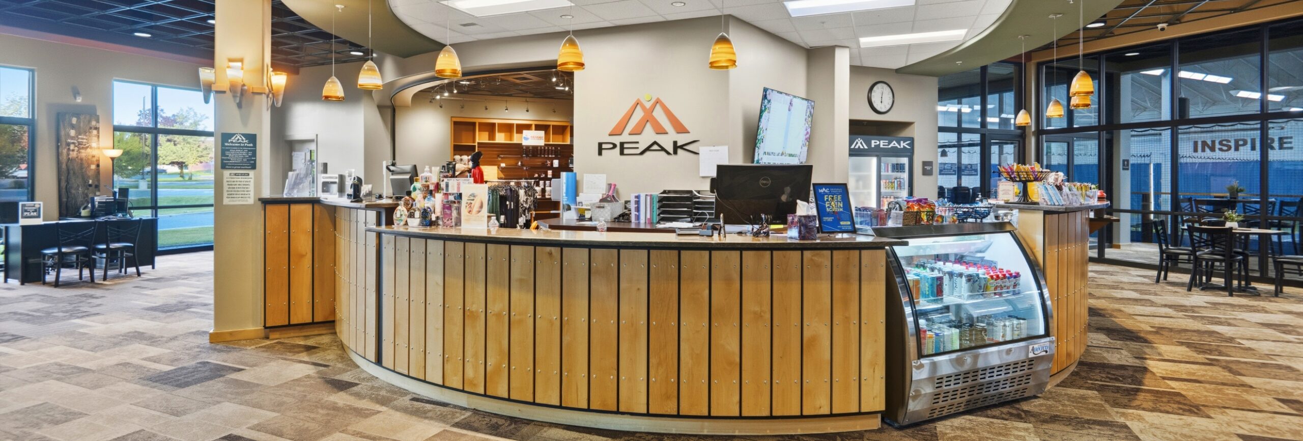 Peak Health & Wellness Hayden membership desk and juice bar with seating and indoor tennis court views.